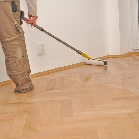 Handwerker Bodenleger versiegelt, lackiert das Parkett. - Handwerker Bodenleger versiegelt, lackiert das Parkett.